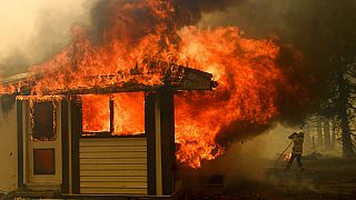 A firefighter battles the Morton Fire as it consumes a home near Bundanoon, New South Wales, Australia. January 23 2020