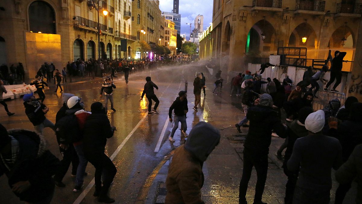 Anti-government protesters clash with the riot police during ongoing protests in Beirut, Lebanon, Wednesday, Jan. 22, 2020.