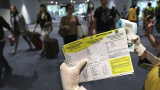 A health official holds a health alert card at the Soekarno-Hatta International Airport in Tangerang, Indonesia, Wednesday, Jan. 22, 2020
