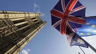 Flags and an umbrella are tied to raiings opposite Britain's parliament buildings in London, Tuesday, Oct. 22, 2019. 