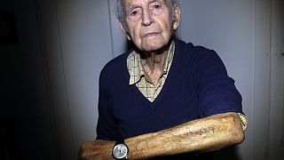 In this Saturday, Jan. 4, 2020 photo Holocaust and Auschwitz survivor Leon Schwarzbaum shows his tattooed identification number in his home in Berlin.