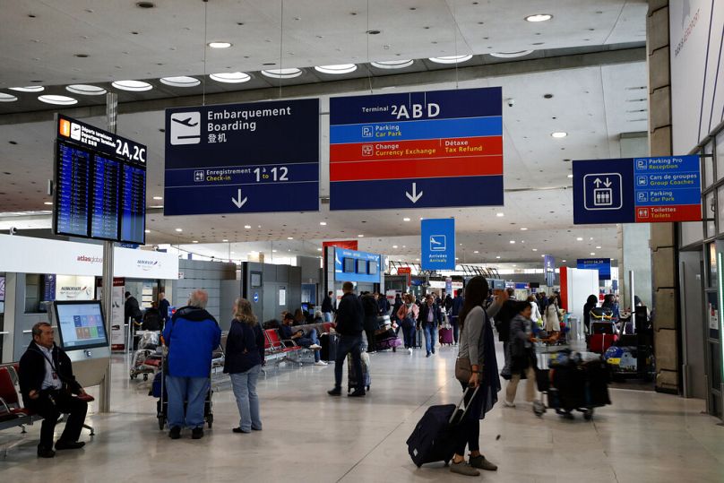 Passageiros aguardam no átrio de chegadas do aeroporto Charles de Gaulle, em Roissy, perto de Paris - poderão os futuros viajantes enfrentar perturbações?
