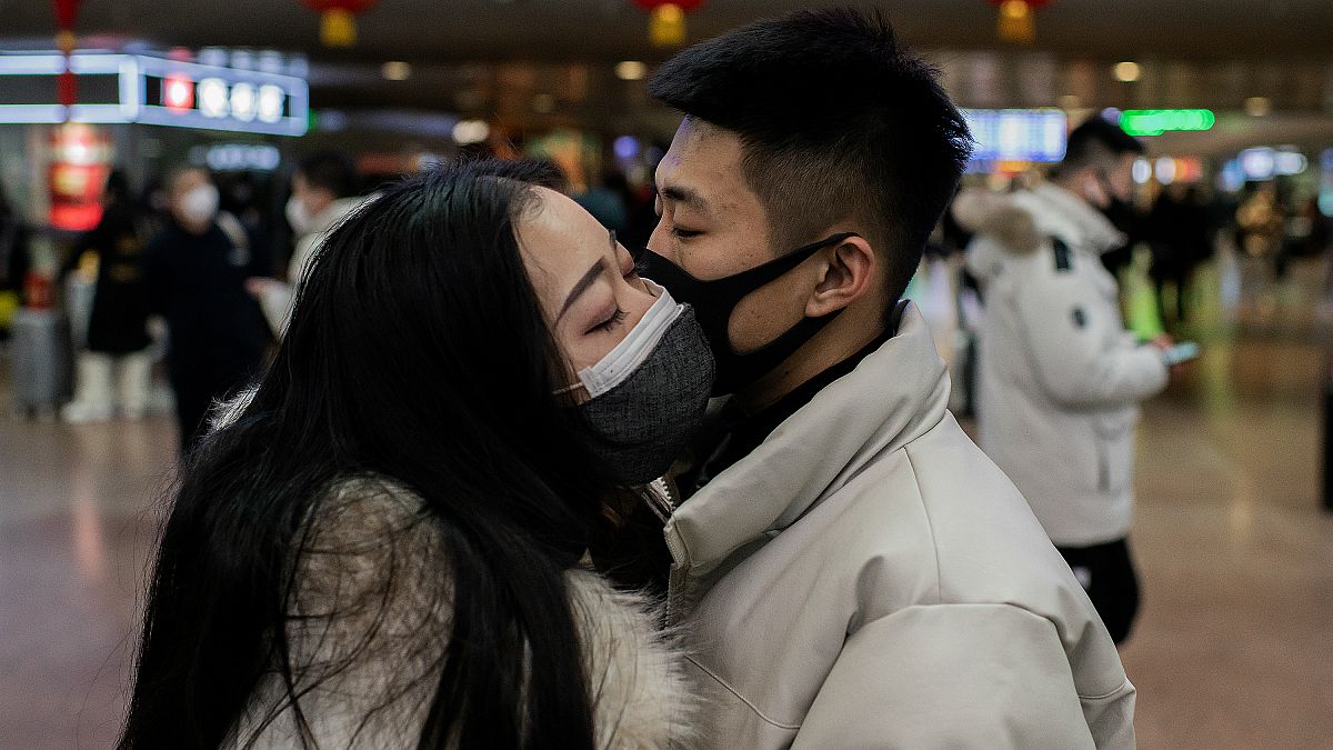 Çin'in başkenti Pekin'deki tren istasyonunda birbirine veda eden bir çift. Yetkililer tüm vatandaşları maske takmaları konusunda uyarıyor