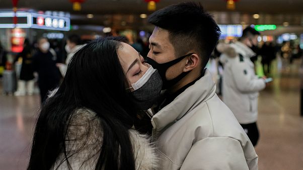 Çin'in başkenti Pekin'deki tren istasyonunda birbirine veda eden bir çift. Yetkililer tüm vatandaşları maske takmaları konusunda uyarıyor Çin'in başkenti Pekin'deki tren istasyonunda birbirine veda eden bir çift. Yetkililer tüm vatandaşları maske takmaları konusunda uyarıyor