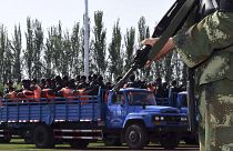 Doğu Türkistan'da 'terör' ve 'ayrılıkçılıkla' suçlanan kişiler kamyonla götürülürken (arşiv) 