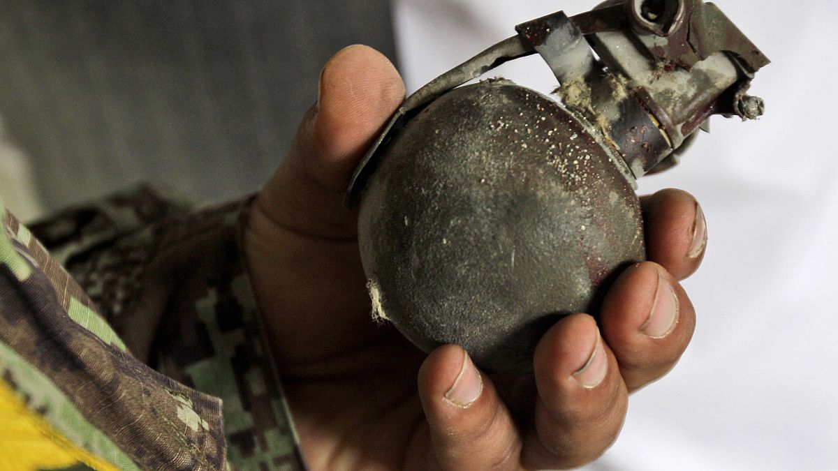 Afgan askeri el bombasını tutuyor