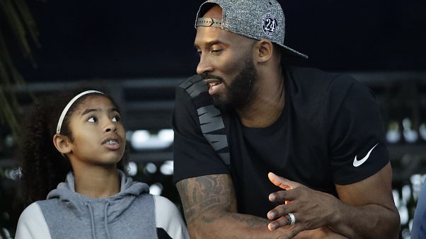 In this July 26, 2018 file photo former Los Angeles Laker Kobe Bryant and his daughter Gianna watch the U.S. national championships swimming meet in Irvine, Calif. In this July 26, 2018 file photo former Los Angeles Laker Kobe Bryant and his daughter Gianna watch the U.S. national championships swimming meet in Irvine, Calif.