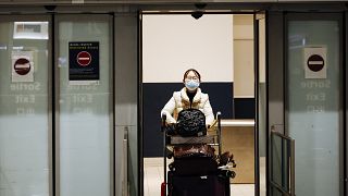 A traveler coming from Beijing and wearing a mask arrives at Charles de Gaulle airport, Paris. 