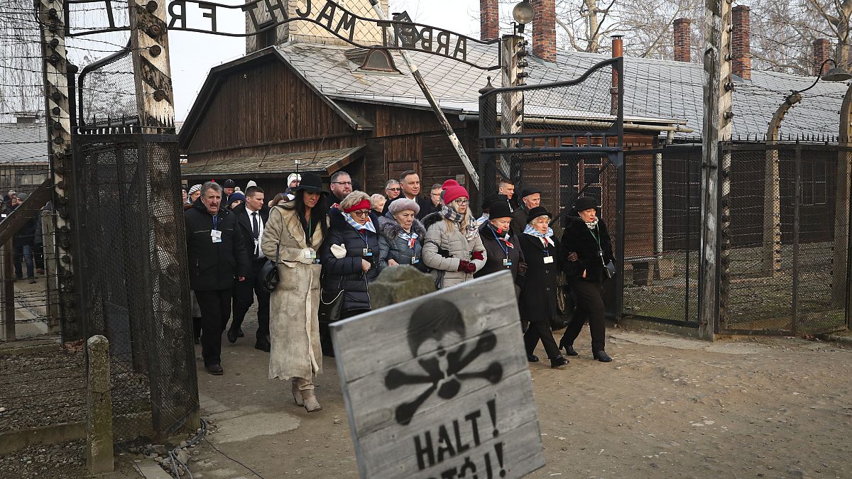 Poland's President Andrzej Duda walks with survivors through the gates of Auschwitz the 75th anniversary of its liberation Monday, Jan. 27, 2020.