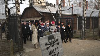 Poland's President Andrzej Duda walks with survivors through the gates of Auschwitz the 75th anniversary of its liberation Monday, Jan. 27, 2020.