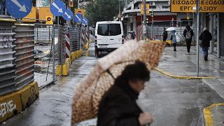 Μία γυναίκα περπατάει στο κέντρο της Θεσσαλονίκης μία βροχερή χειμωνιάτικη ημέρα (αρχείου)