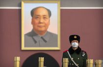 جندي صيني أمام صورة للزعيم الشيوعي الصيني ماو تسي تونغ في ساحة تيانانمن