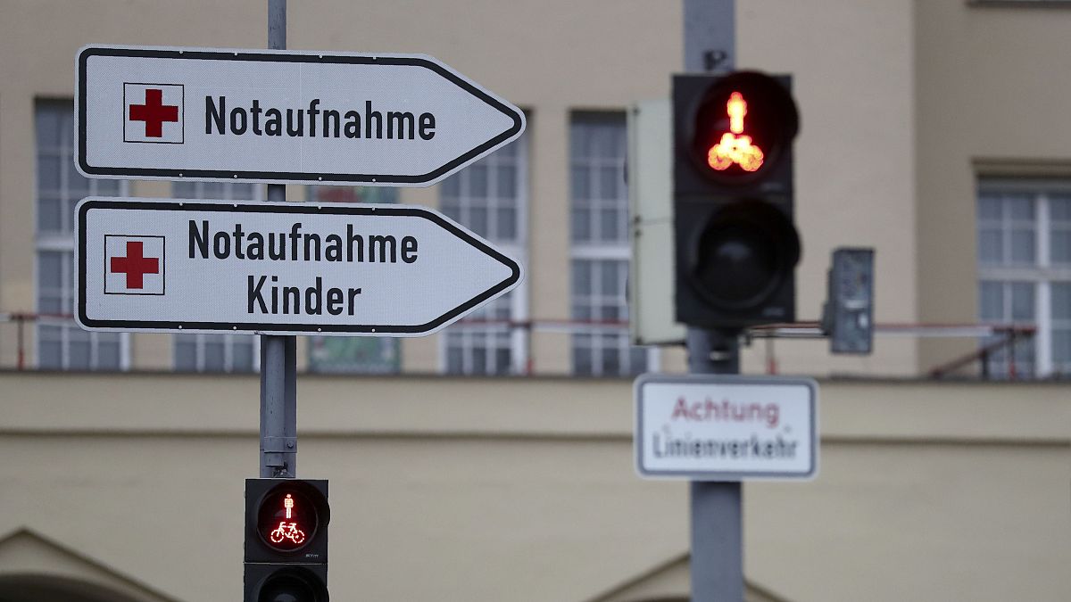 Signposts stand in front of the main entrance of a hospital in Munich.