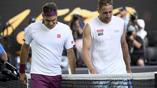 Roger Federer, left, walks with Tennys Sandgrenafter winning their quarterfinal match at the Australian Open tennis championship in Melbourne, Australia