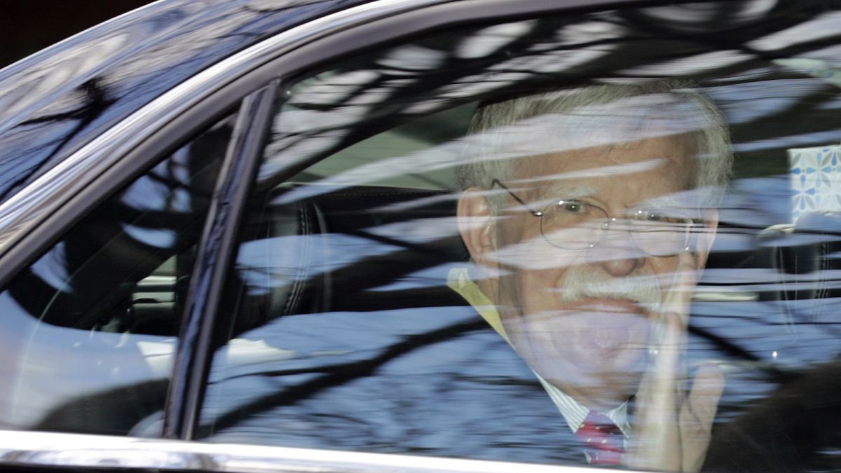 Former National security adviser John Bolton waves as he leaves his home in Bethesda, Md. Tuesday, Jan. 28, 2020
