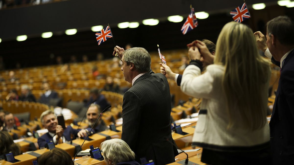 British European Parliament member Nigel Farage, left, and other pro-Brexit British MEP's wave the Union flags.