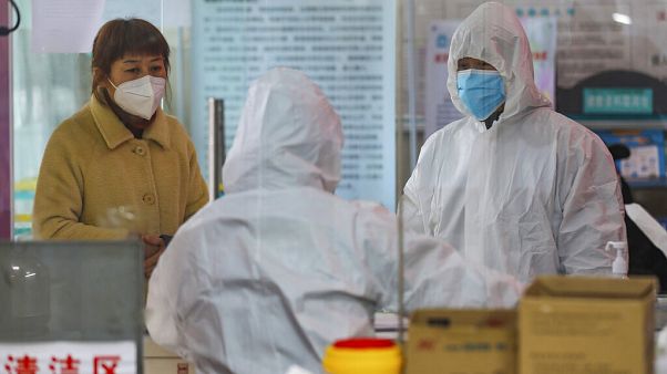 Medical workers in protective gear talk with a woman suspected of being ill with a coronavirus at a community health station in Wuhan in central China's Hubei Province Medical workers in protective gear talk with a woman suspected of being ill with a coronavirus at a community health station in Wuhan in central China's Hubei Province