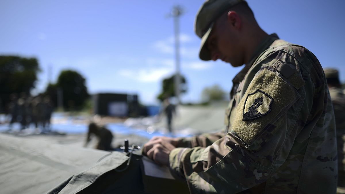 أحد أفراد احتياطي الجيش الأمريكي يعمل على إعداد وحدات دش محمولة في مدينة خيام لمئات الأشخاص النازحين بسبب الزلازل في غوانيكا ، بورتوريكو ، الثلاثاء ، 14 يناير ، 2020
