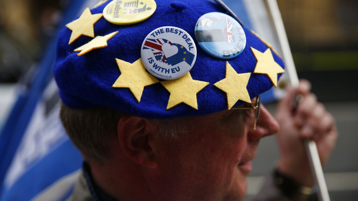 متظاهر مناهض لخروج بريطانيا من الاتحاد الأوروبي يرتدي شارات على قبعة بتصميم علم أوروبي أثناء مظاهرة أمام مجلس النواب في لندن، الخميس 26 سبتمبر 2019. 