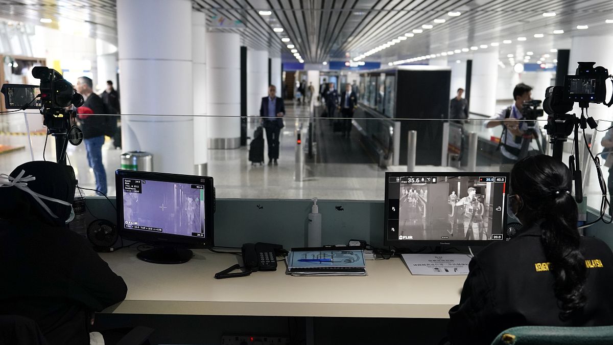 Health officials watch thermographic monitors at a quarantine inspection area at Kuala Lumpur International Airport.