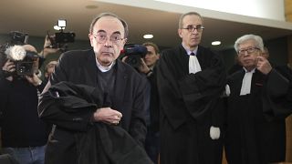 Cardinal Philippe Barbarin takes his seat as he arrives at the Lyon courthouse with his lawyers to attend his trial, in Lyon, Monday Jan. 7, 2019
