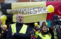 protestors stand in front of a banner which reads "Euthanasia Stop", during an anti-euthanasia demonstration in Brussels in February 2014.