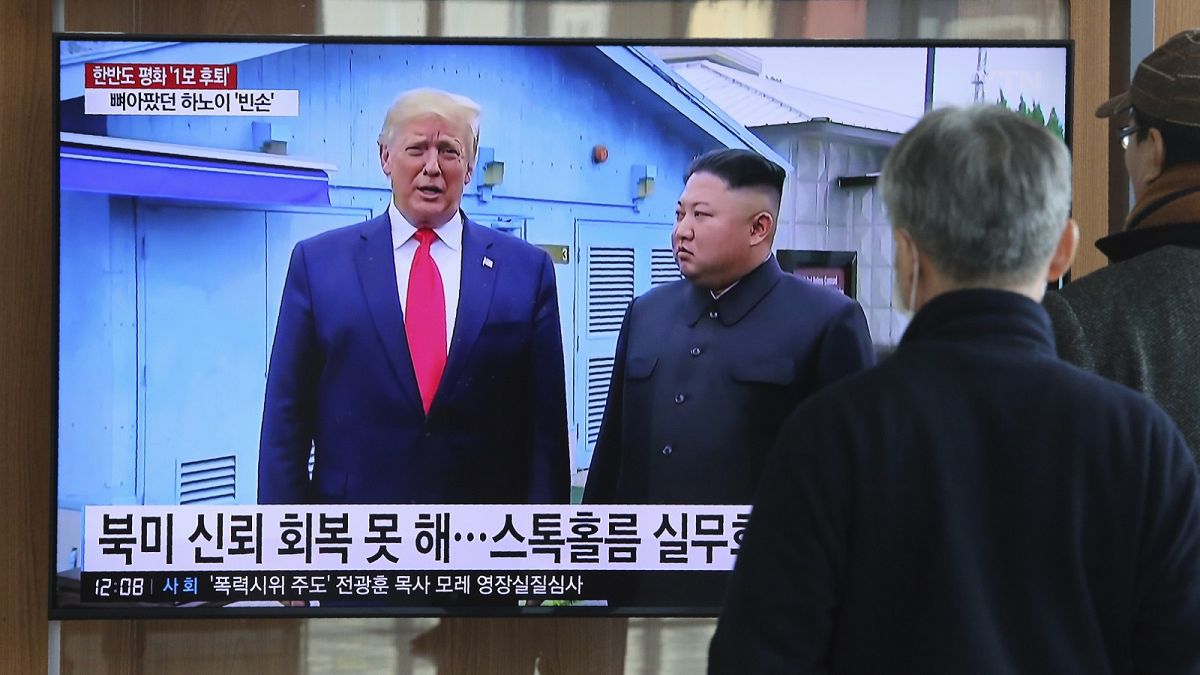 People watch a TV screen showing a file image of North Korean leader Kim Jong Un and U.S. President Donald Trump, during a news program at the Seoul Railway Station