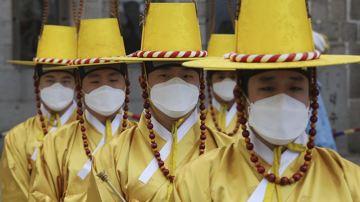 Güney Kore'nin Seul kentinde imparatorluk muhafızları, Deoksu Sarayı önünde Kraliyet Muhafızları Değiştirme Töreni canlandırması sırasında yüz maskesi takıyor