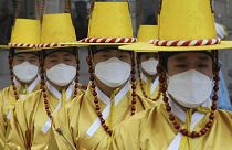 سربازان گارد امپراطوری در برابر کاخ سلطنتی کرهٔ جنوبی واقع در سئول ماسک تنفسی بر چهره دارند