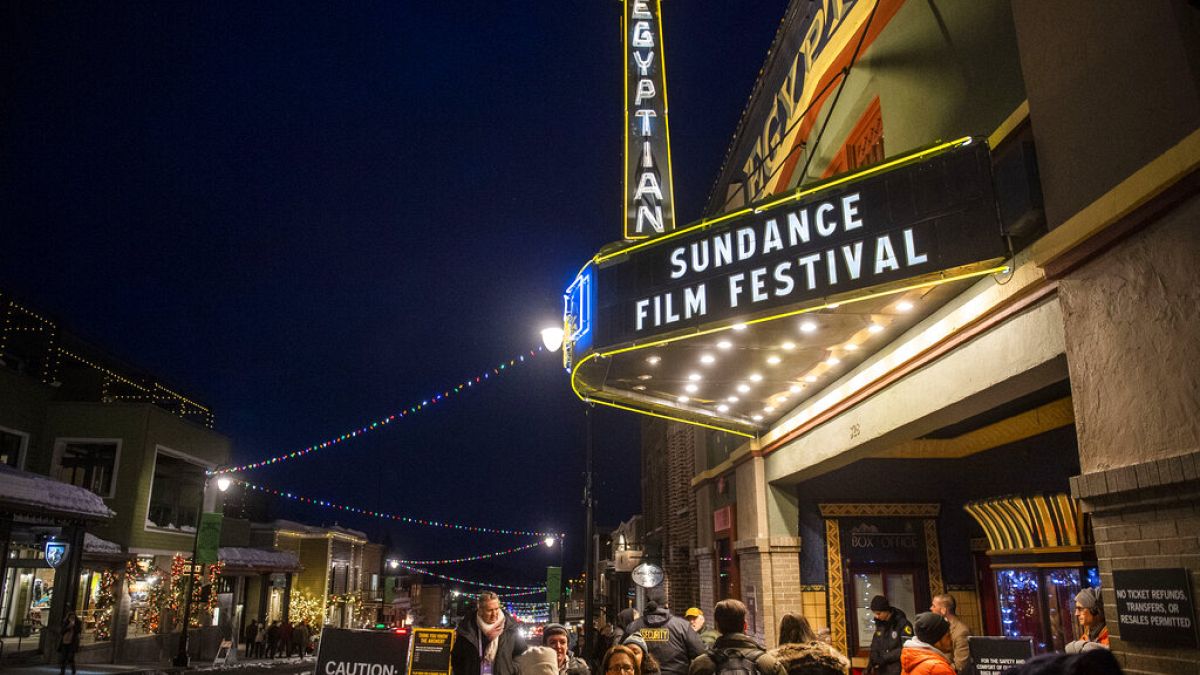 People walk under the marquee of the Egyptian Theatre on the sixth day of the 2020 Sundance Film Festival.