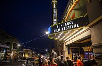 People walk under the marquee of the Egyptian Theatre on the sixth day of the 2020 Sundance Film Festival.