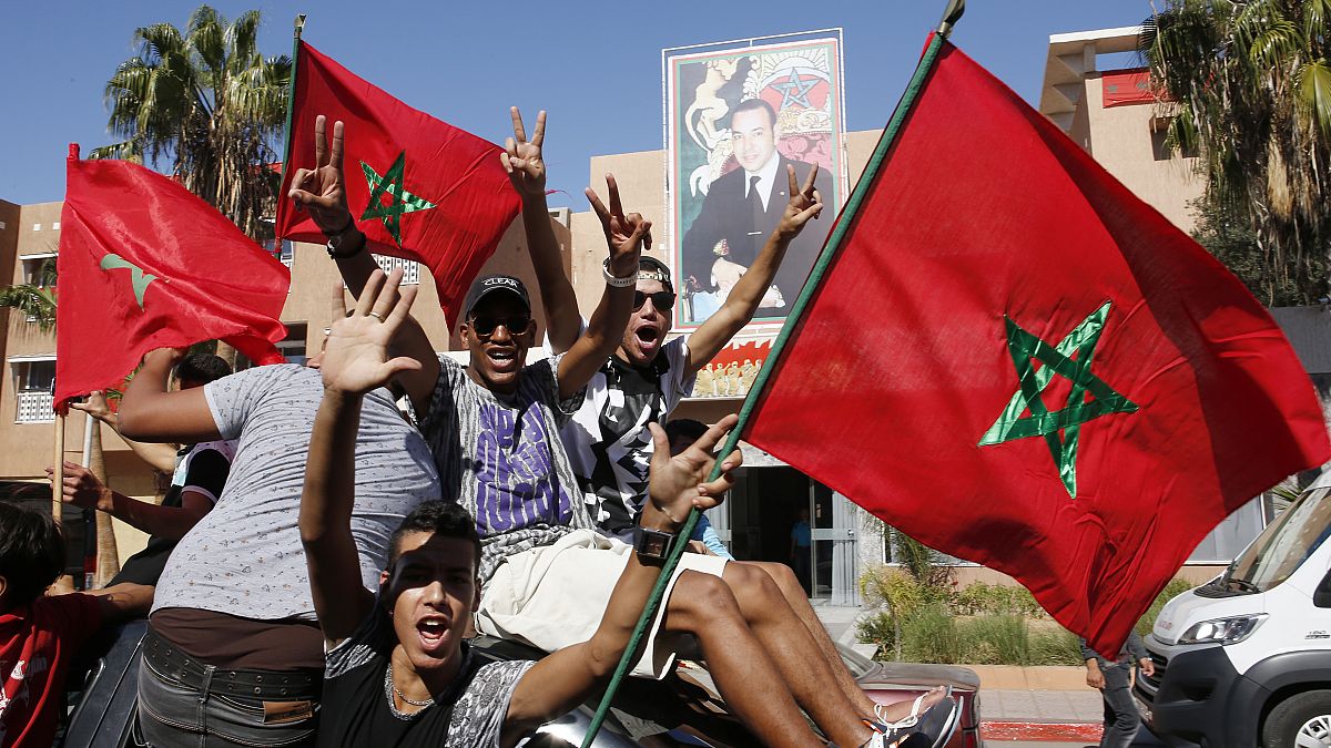 متظاهرون مغربيون يرفعون العلم المغربي في العيون، عاصمة الصحراء الغربية المتنازع عليها 