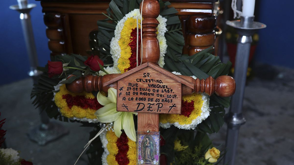 A cross bearing the name of Mexican journalist Jorge Celestino Ruiz Vazquez is displayed near the coffin containing his remains in Actopan, Veracruz, Saturday, Aug. 3, 2019