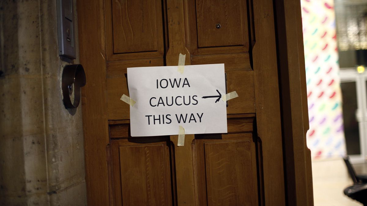 A placard reading « Iowa Caucus this way » hangs on a door, in Paris on Feb. 3, 2020. Paris is one of just three satellite caucus locations outside the U.S.