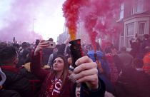 Football supporters set off flares before the English Premier League soccer match between Liverpool and Manchester United near Anfield Stadium in Liverpool.