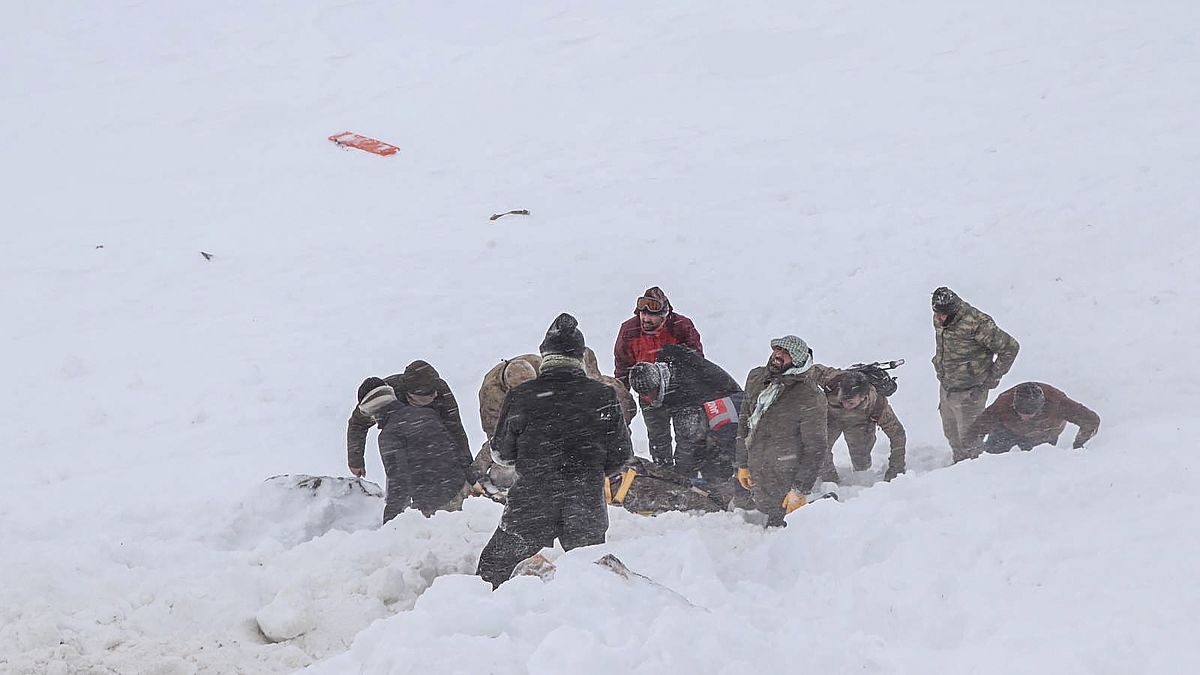 Security officers and villagers carry a victim of an avalanche near the town of Bahcesehir, in the eastern Turkey province of Van, on February 5, 2020.