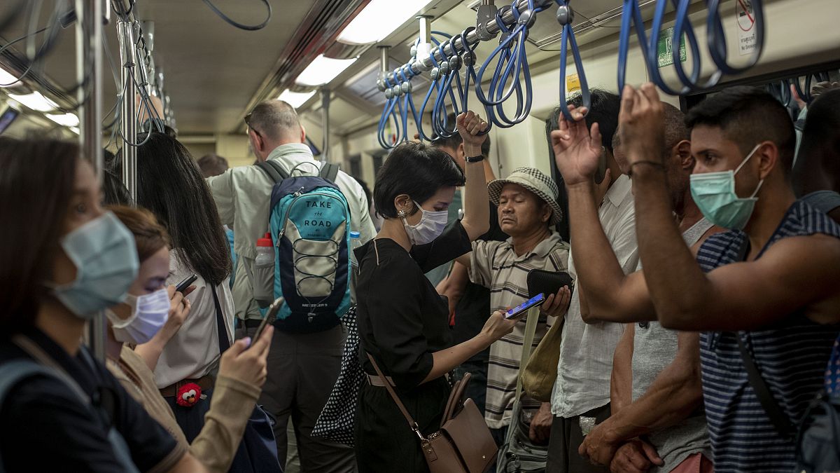 أشخاص يرتدون الأقنعة ويركبون مترو الأنفاق 