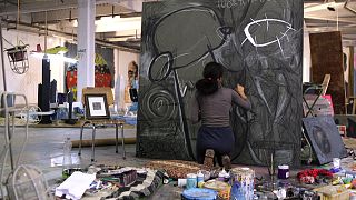 Artist Tara Abdullah paints in her studio, located inside an old tobacco factory