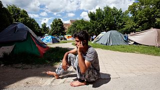 Un migrant originaire du Pakistan parle au téléphone dans le parc en face de la mairie de Sarajevo, en Bosnie, le jeudi 17 mai 2018.