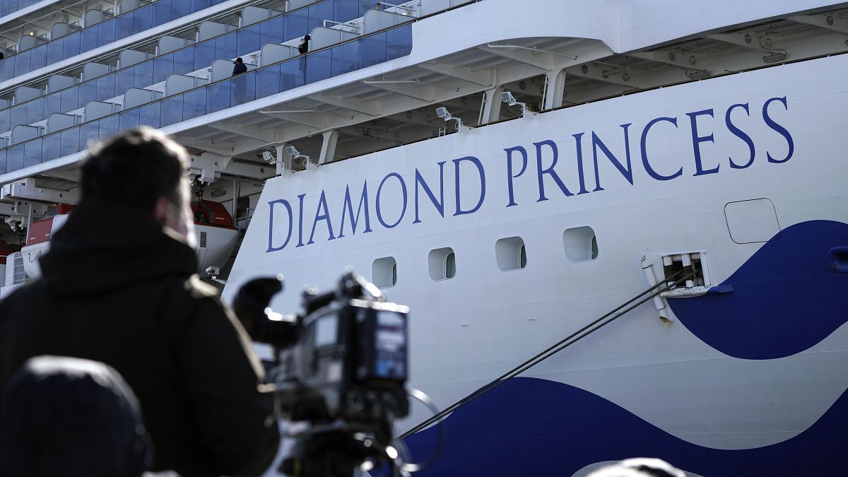 Un periodista con su cámara junto al crucero Diamond Princess, Yokohama, Japón