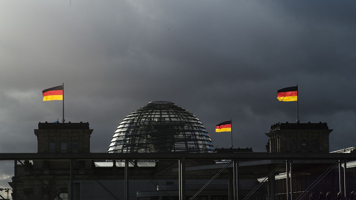 German national flags catch the sun on top of the German parliament building, the Reichstag building in Berlin, Germany, Friday, Nov. 29, 2019. 