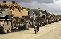 Turkish military convoy drives through the village of Binnish, in Idlib province, Syria, Saturday, Feb. 8, 2020.