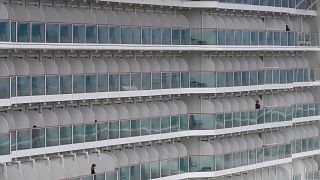 Passenger are seen from the World Dream cruise ship docked at Kai Tak cruise terminal Hong Kong, Wednesday, Feb. 5, 2020.  (AP Photo/Vincent Yu)