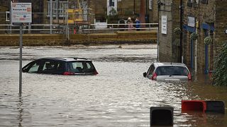 Cars are seen submerged as flood water covers the roads and car parks in Mytholmroyd, northern England.