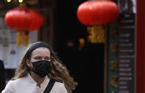 A woman wears a mask as she walks near China Town in London, Friday, Feb. 7, 2020.