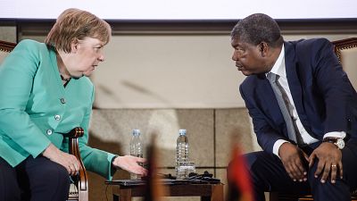 German Chancellor Angela Merkel (L) and Angola's President Joao Lourenco talk during a contract signing ceremony at the German-Angolan economy forum in Luanda