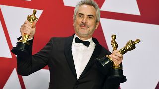 Alfonso Cuaron posa con los premios al mejor director para "Roma", mejor película en lengua"Roma", y mejor fotografía para "Roma" en febrero de 2019 