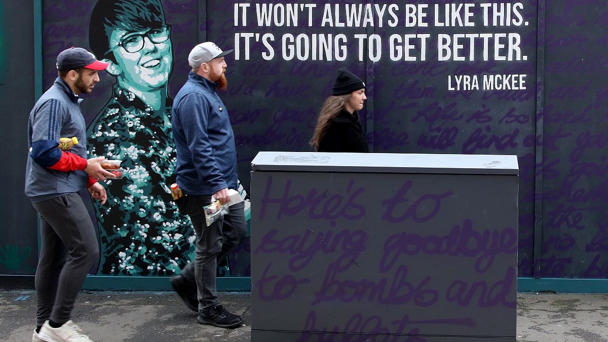 FILE PHOTO: Residents walk past a newly painted mural featuring murdered journalist Lyra McKee in central Belfast on May 7, 2019. 