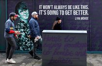 FILE PHOTO: Residents walk past a newly painted mural featuring murdered journalist Lyra McKee in central Belfast on May 7, 2019.