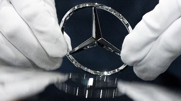 Trabalhador limpa logo da Mercedes Benz numa fábrica da marca Trabalhador limpa logo da Mercedes Benz numa fábrica da marca
